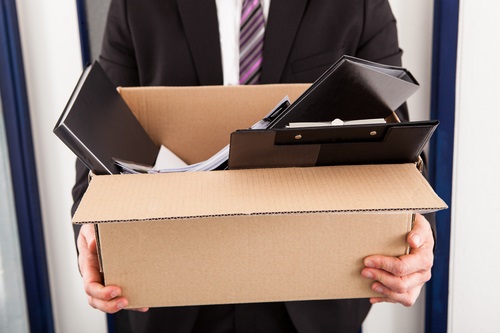 Fired employee leaving office carrying a box