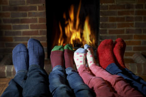 8 sock-clad feet in front of fireplace