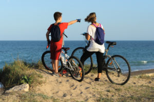 mother and son on bikes for outdoor fitness, stopped by an ocean overlook