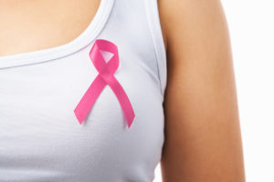 cropped photo of a woman wearing a pink ribbon on a white t-shirt for breast cancer awareness