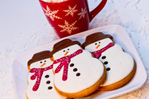 snowman cookies and hot chocolate in a festive snowflake cup to symbolize out holiday survival toolkit