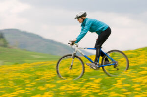 woman riding a bike through a field of spring flowers