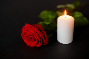 a rose and a burning candle from a mass shooting memorial