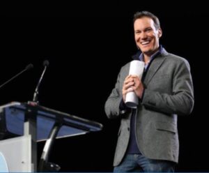 Photo of Shawn Achor at a podium speaking about happiness and success